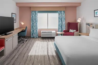 a hotel room with a bed and a desk and a window at Hilton Garden Inn Rockaway in Rockaway