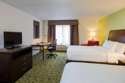 a hotel room with two beds and a desk and a television at Hilton Garden Inn Edison/Raritan Center in Edison