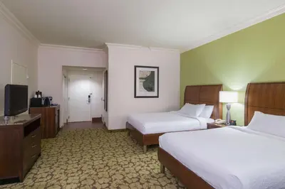 a hotel room with two beds and a flat screen tv at Hilton Garden Inn Edison/Raritan Center in Edison