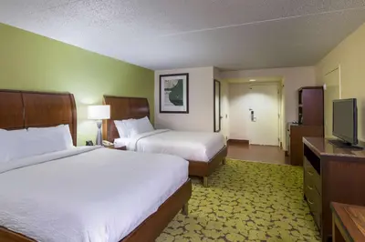 a hotel room with two beds and a flat screen tv at Hilton Garden Inn Edison/Raritan Center in Edison
