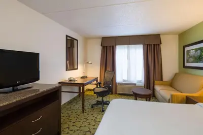a hotel room with a bed and a couch and a television at Hilton Garden Inn Edison/Raritan Center in Edison