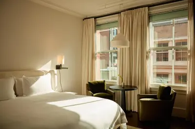 a hotel room with a bed and two chairs and a window at The Mercer in New York