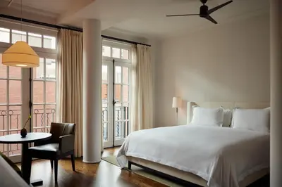 a white bedroom with a bed and a table and chair at The Mercer in New York