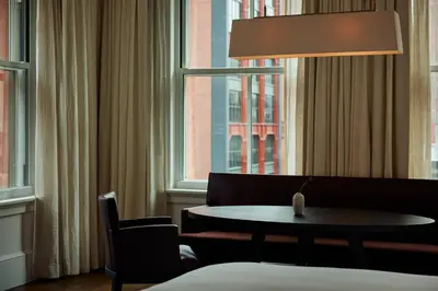 a living room with a table and a window at The Mercer in New York