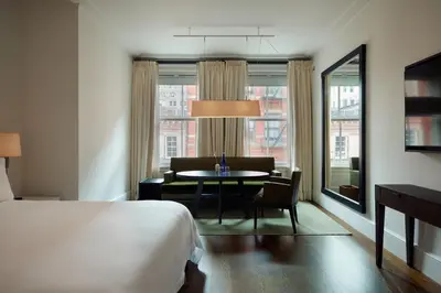 a hotel room with a bed and a table and a window at The Mercer in New York