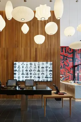 a lobby with a desk and several lights at citizenM New York Bowery in New York