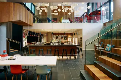 a restaurant with a bar with stools at citizenM New York Bowery in New York