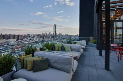 a balcony with couches and a view of a city at citizenM New York Bowery in New York