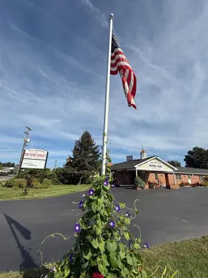a christmas tree with an american flag on a pole at Weathervane Motor Court in Ronks