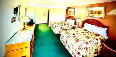 a hotel room with two beds and a desk at Weathervane Motor Court in Ronks