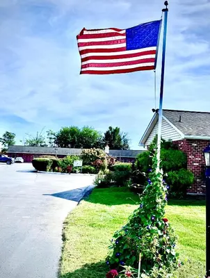 an american flag flying in front of a house at Weathervane Motor Court in Ronks