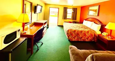 a hotel room with a bed and a television at Weathervane Motor Court in Ronks