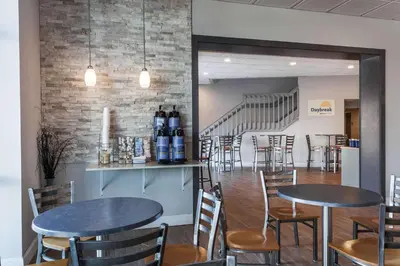 a restaurant with two tables and chairs and a staircase at Days Inn & Suites by Wyndham Lancaster Amish Country in Lancaster