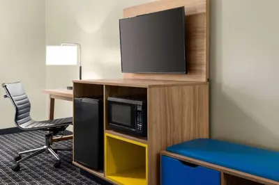 a room with a tv and a desk and a chair at Days Inn & Suites by Wyndham Lancaster Amish Country in Lancaster