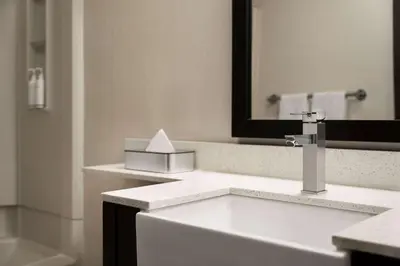 a bathroom with a sink and a mirror at Days Inn & Suites by Wyndham Lancaster Amish Country in Lancaster