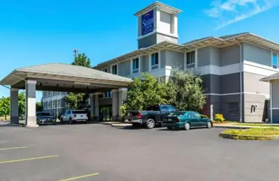 a parking lot in front of a building with a clock tower at Sleep Inn & Suites Dunmore in Dunmore