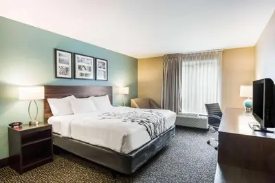 a hotel room with a bed and a television at Sleep Inn & Suites Dunmore in Dunmore