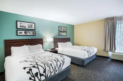 a hotel room with two beds and a window at Sleep Inn & Suites Dunmore in Dunmore
