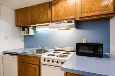a small kitchen with a stove and a sink at Econo Lodge Inn & Suites Lake Harmony - Pocono Mountains Area in White Haven
