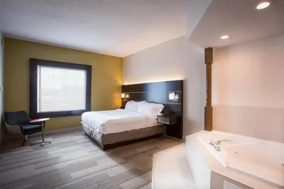 a hotel room with a bed and a bath tub at Holiday Inn Express Hotel & Suites Reading by IHG in Reading