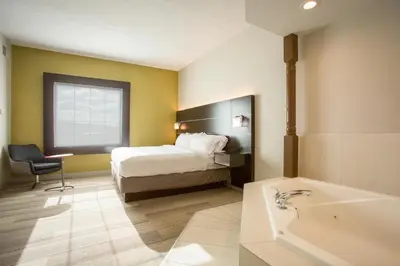 a hotel room with a bed and a bath tub at Holiday Inn Express Hotel & Suites Reading by IHG in Reading