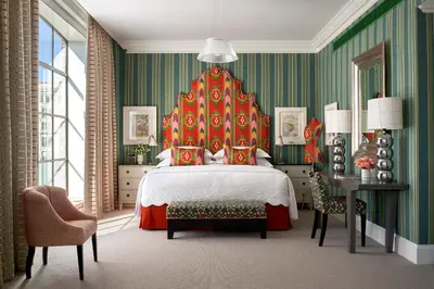 a bedroom with a large bed with a red headboard at Crosby Street Hotel in New York