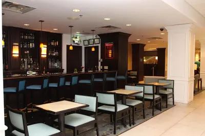 a bar with tables and chairs in a restaurant at Holiday Inn Budd Lake - Rockaway Area by IHG in Budd Lake