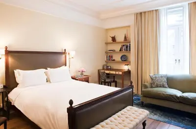 a bedroom with a bed and a chair and a window at The Greenwich Hotel in New York