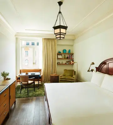 a bedroom with a bed and a table and a desk at The Greenwich Hotel in New York