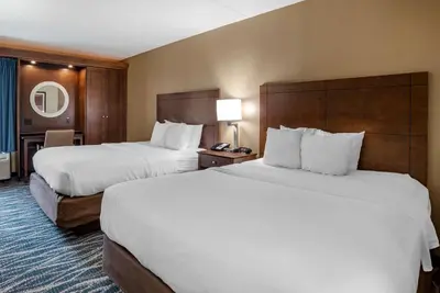 a hotel room with two beds with white sheets at Comfort Inn & Suites Newark - Wilmington in Newark