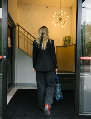 a woman walking down the hallway of a building at The Gatsby Hotel in New York