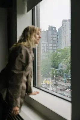 a person is looking out of a window at The Gatsby Hotel in New York