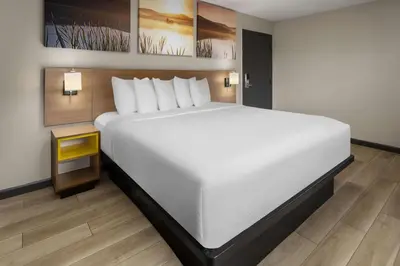 a large white bed in a room with a table at Days Inn by Wyndham Wurtsboro in Wurtsboro
