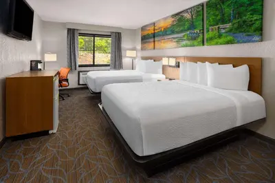 a hotel room with two beds and a desk at Days Inn by Wyndham Wurtsboro in Wurtsboro