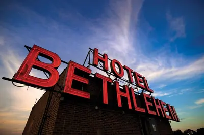 a red neon sign on top of a building at Historic Hotel Bethlehem in Bethlehem