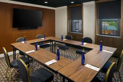 a conference room with wooden tables and chairs and a flat screen tv at Historic Hotel Bethlehem in Bethlehem