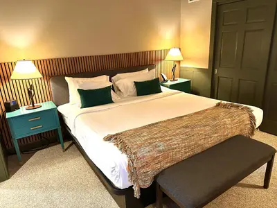 a bedroom with a large bed with two night stands at Minnewaska Lodge in Gardiner