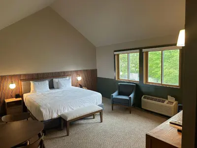 a bedroom with a bed and a desk and a chair at Minnewaska Lodge in Gardiner
