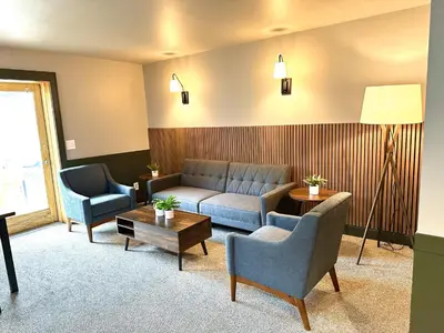 a living room with a couch and two chairs at Minnewaska Lodge in Gardiner