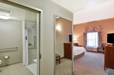 a hotel room with a bed and a bathroom at Hampton Inn Lewisburg in Lewisburg