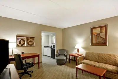 a hotel room with a couch and a table and chairs at Hampton Inn Lewisburg in Lewisburg