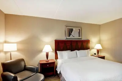 a hotel room with a bed and a chair at Hampton Inn Lewisburg in Lewisburg