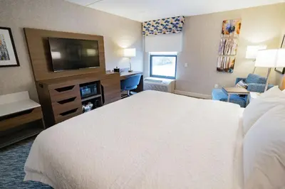 a hotel room with a bed and a flat screen tv at Hampton Inn Clarks Summit in Clarks Summit