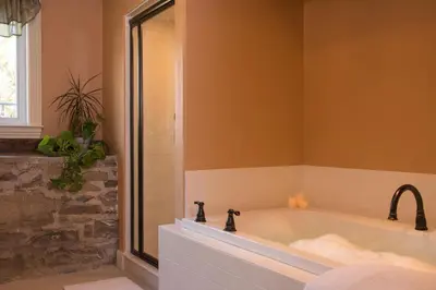 a bathroom with a large tub with a window at Caldwell House Bed and Breakfast in Salisbury Mills