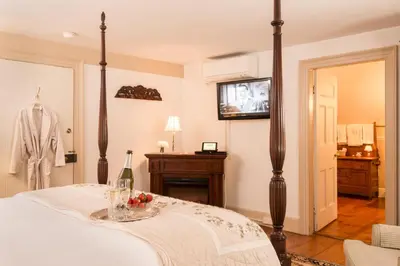 a bedroom with a bed and a tv on a wall at Caldwell House Bed and Breakfast in Salisbury Mills