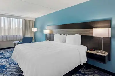 a large white bed in a hotel room at Best Western Rutgers University Hotel in East Brunswick