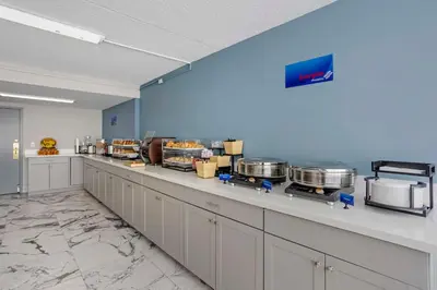 a large kitchen with a counter with some pots and pans at Best Western Rutgers University Hotel in East Brunswick