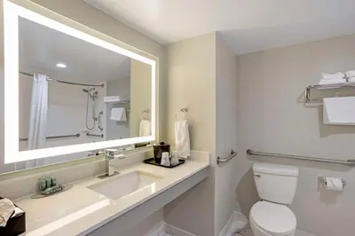 a bathroom with a toilet and a sink and a mirror at Best Western Rutgers University Hotel in East Brunswick
