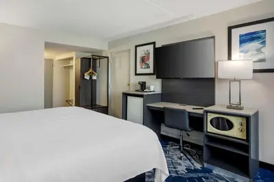 a hotel room with a bed and a desk and a tv at Best Western Rutgers University Hotel in East Brunswick