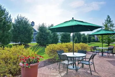 a patio with tables and chairs and an umbrella at Hampton Inn Sayre in Sayre